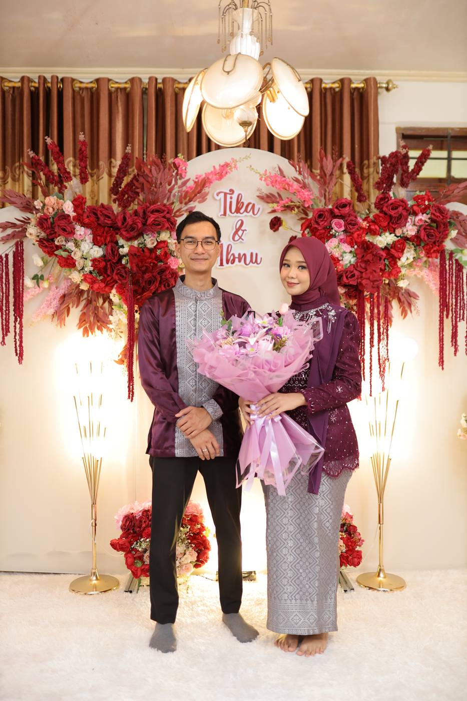 Ibnu dan Tika berdiri memegang buket